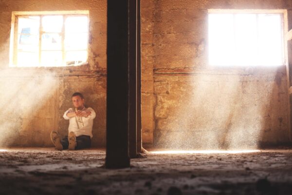 Man Drinking On Floor In Farm Stall